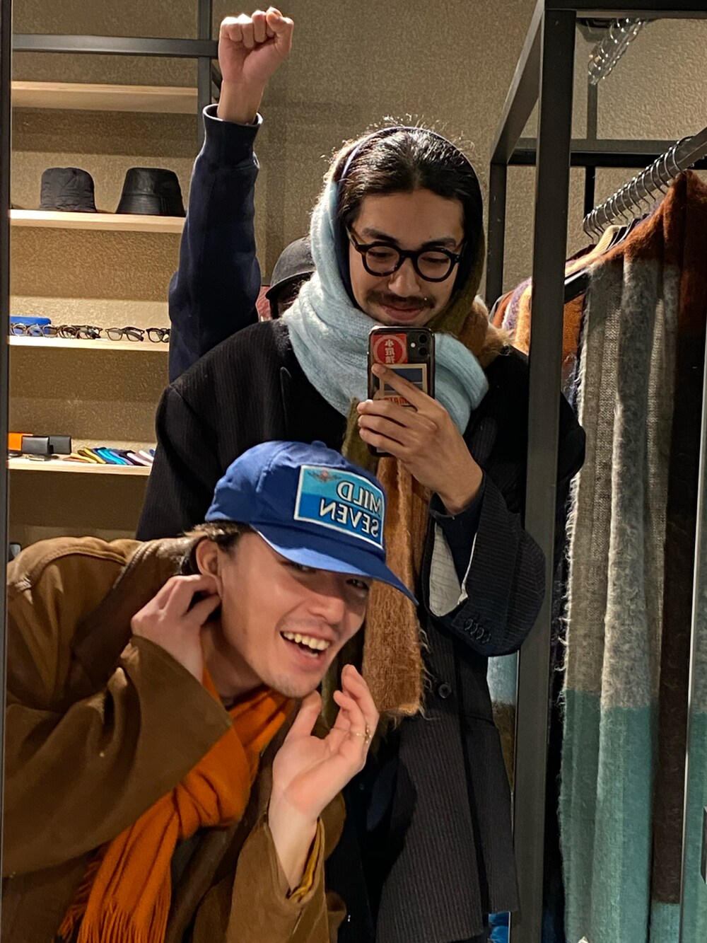 ブラウン系のジャケット/アウター、ピンク系のマフラー、ブラック系のメガネを着用したメンズの冬コーディネートの2枚目の写真