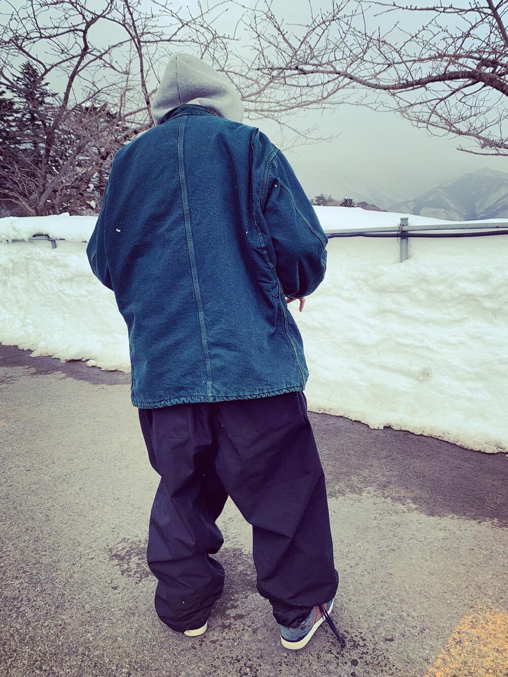 グリーン系のダウンジャケット/コート、ブラック系のパンツ、ブルー系のスニーカーを着用したメンズの冬コーディネートの2枚目の写真