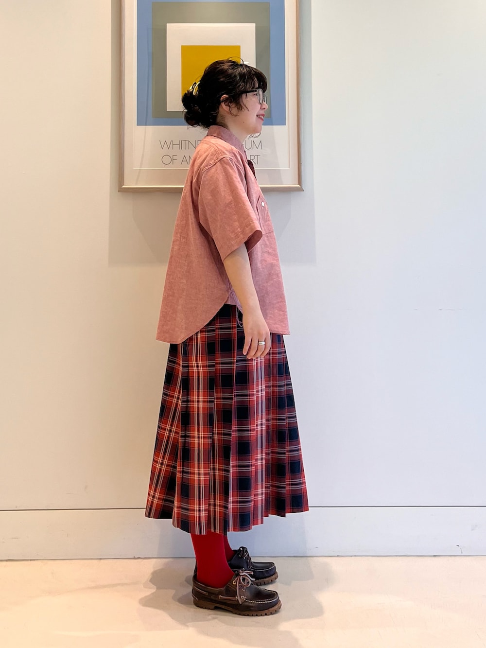 レッド系のシャツ/ブラウス、レッド系のスカート、ブラウン系のモカシン/デッキシューズを着用したレディースの春コーディネートの3枚目の写真