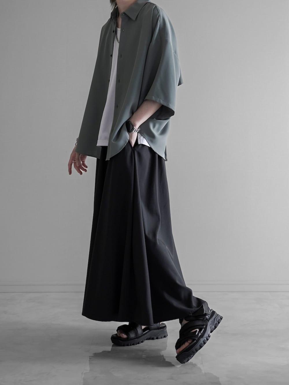 グリーン系のシャツ/ブラウス、ホワイト系のタンクトップ、ブラック系のスラックスを着用したメンズの夏コーディネートの5枚目の写真