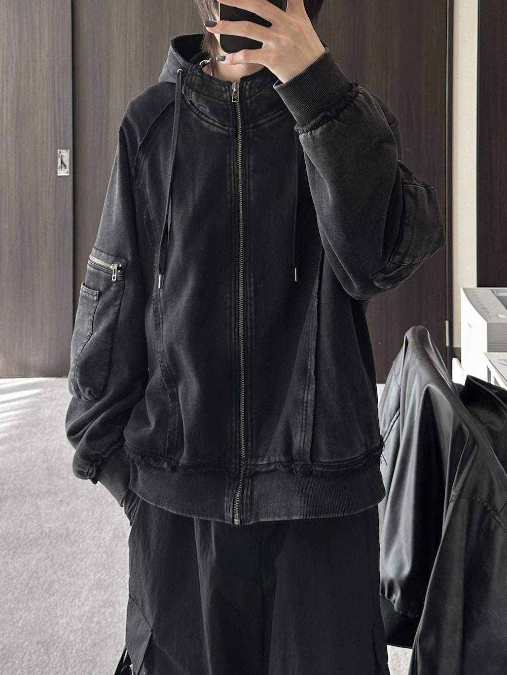 ブラック系のブルゾン、ブラック系のパーカー、ブラック系のカーゴパンツを着用したメンズの冬コーディネートの5枚目の写真