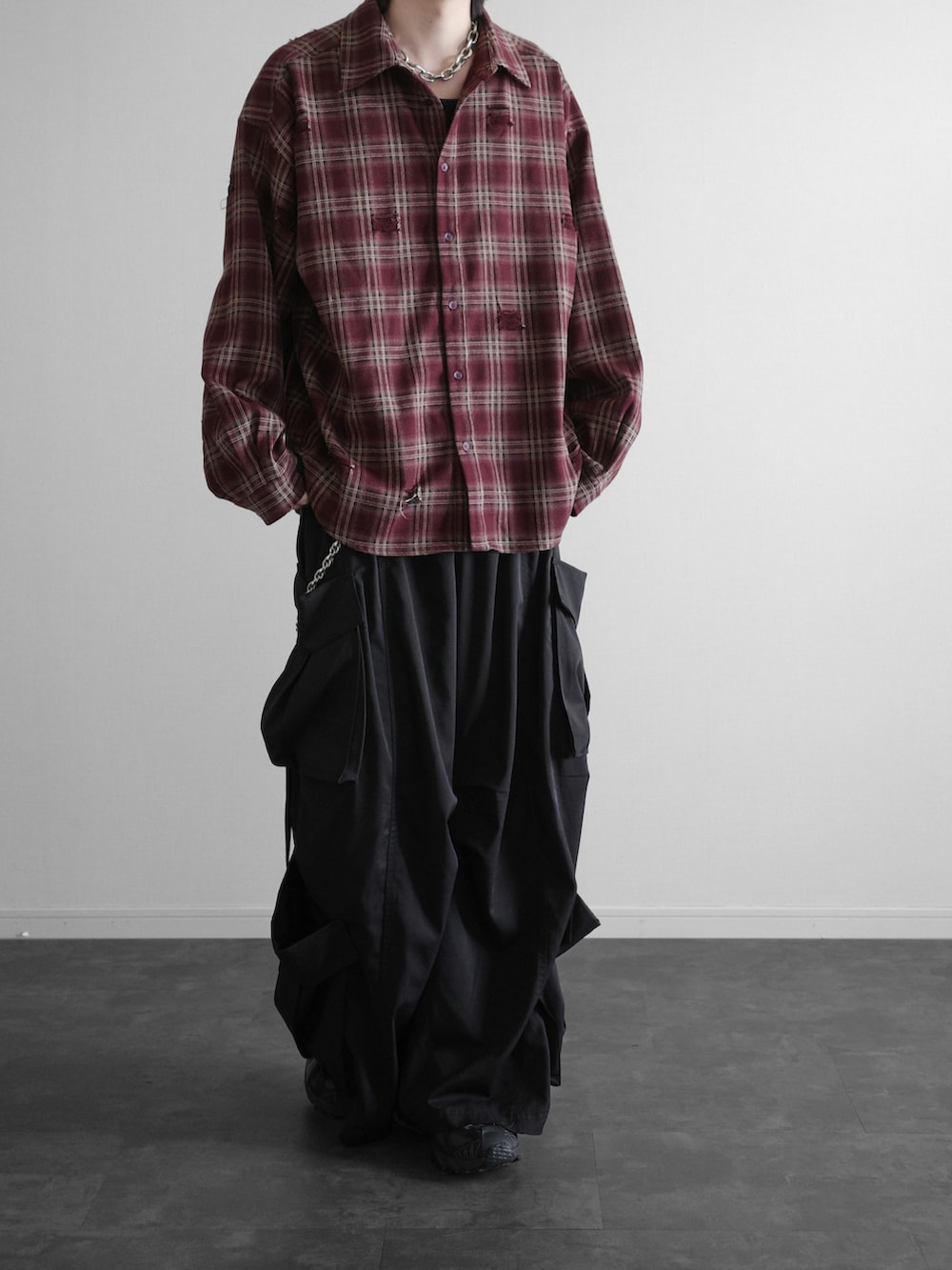 レッド系のシャツ/ブラウス、ブラック系のカーゴパンツ、ブラック系のスニーカーを着用したメンズの冬コーディネートの2枚目の写真