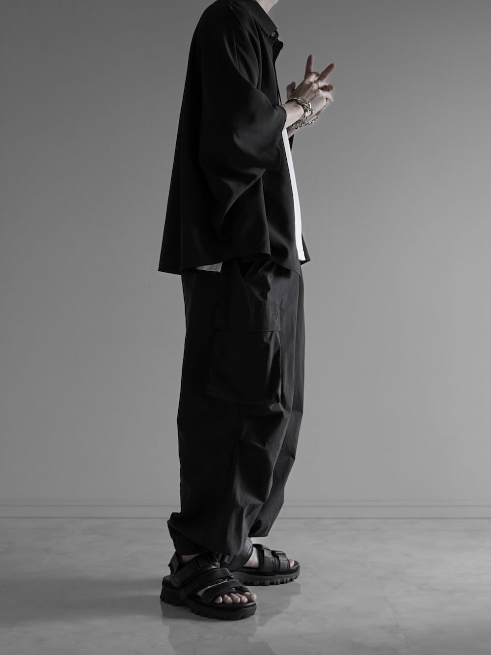 ブラック系のシャツ/ブラウス、ホワイト系のタンクトップ、ブラック系のカーゴパンツを着用したメンズの夏コーディネートの2枚目の写真