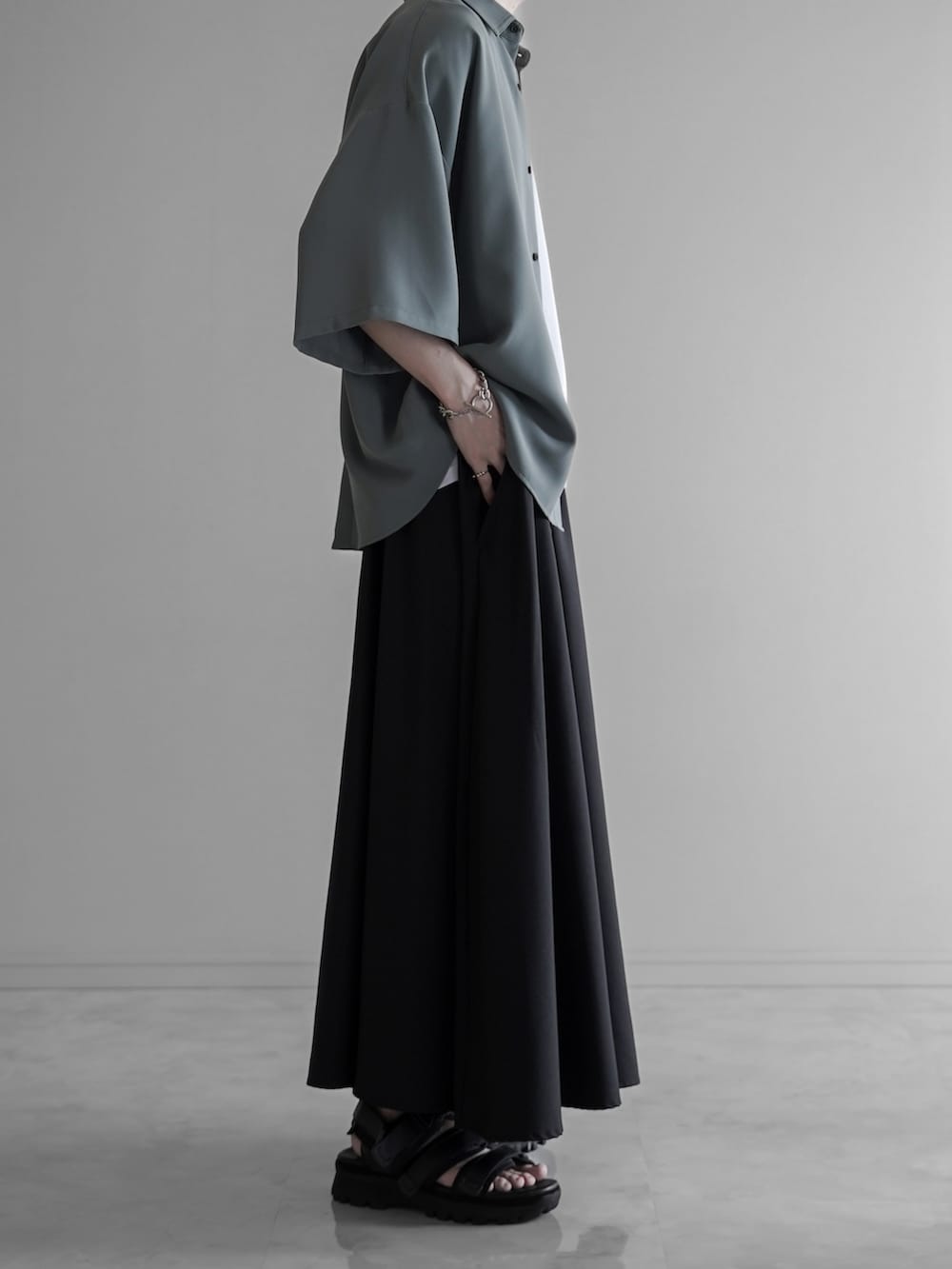 グリーン系のシャツ/ブラウス、ホワイト系のタンクトップ、ブラック系のスラックスを着用したメンズの夏コーディネートの3枚目の写真