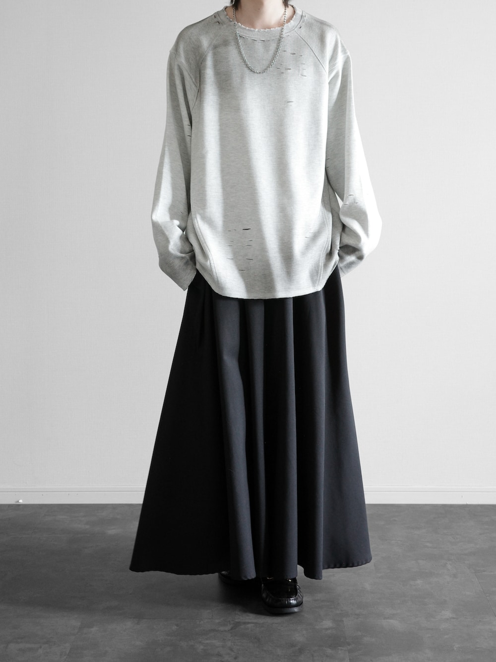 グレー系のTシャツ/カットソー、ブラック系のスラックス、ブラック系のローファーを着用したメンズの秋コーディネートの5枚目の写真