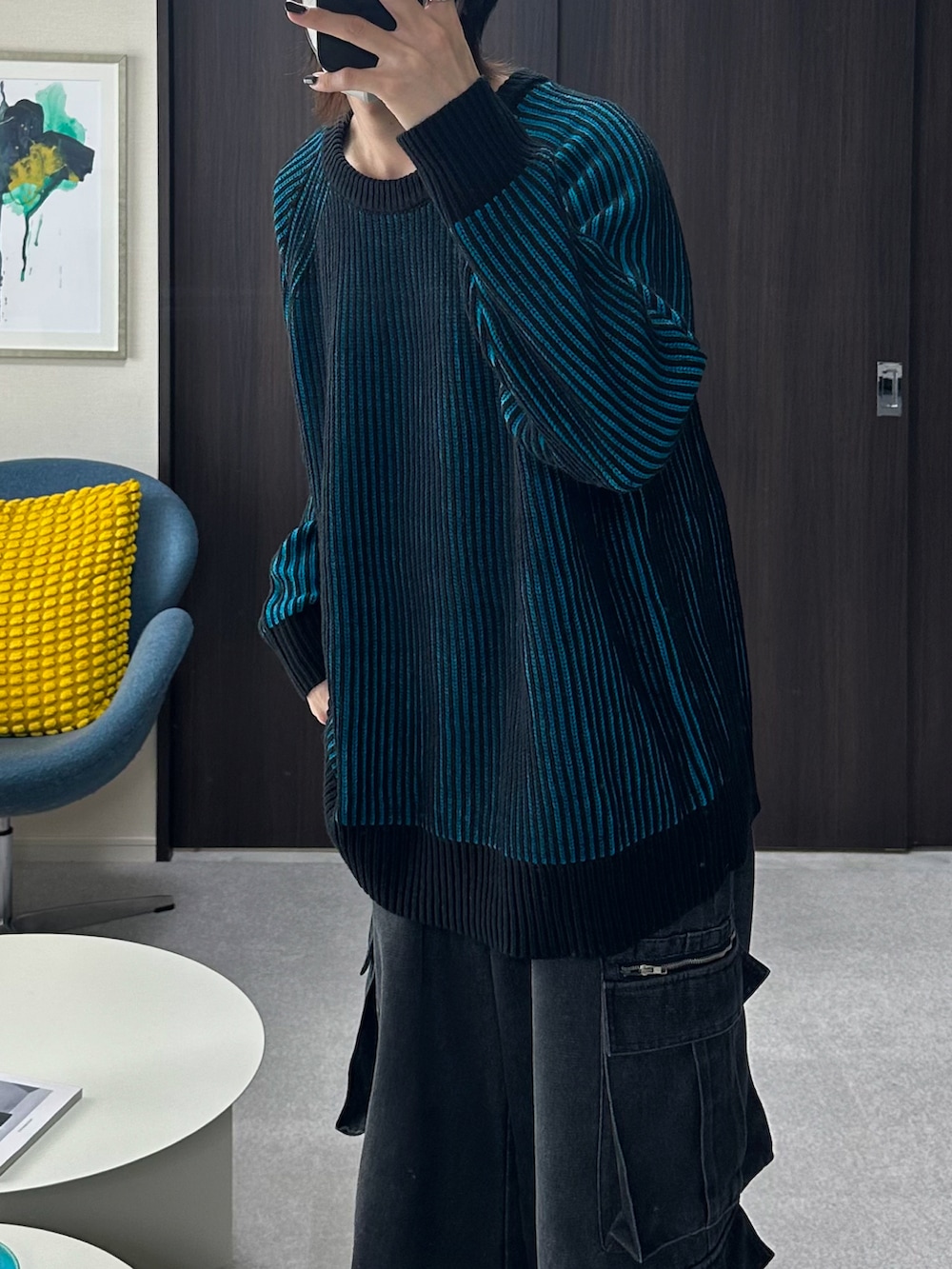 ブラック系のダウンジャケット/コート、ブルー系のニット/セーター、ブラック系のカーゴパンツを着用したメンズの冬コーディネートの3枚目の写真