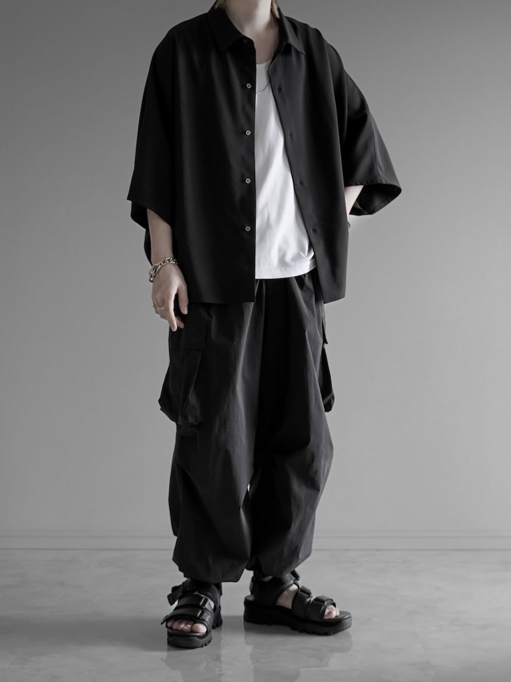 ブラック系のシャツ/ブラウス、ホワイト系のタンクトップ、ブラック系のカーゴパンツを着用したメンズの夏コーディネートの4枚目の写真