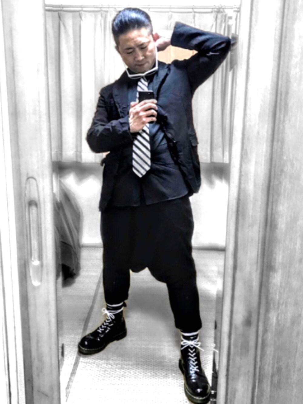 ブラック系のブーツ、グリーン系のモッズコート、ブラック系のテーラードジャケットを着用したメンズの秋コーディネートの3枚目の写真