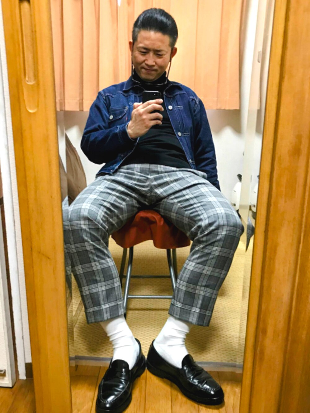 ブルー系のデニムジャケット、ブラック系のニット/セーター、グレー系のスラックスを着用したメンズの春コーディネートの2枚目の写真