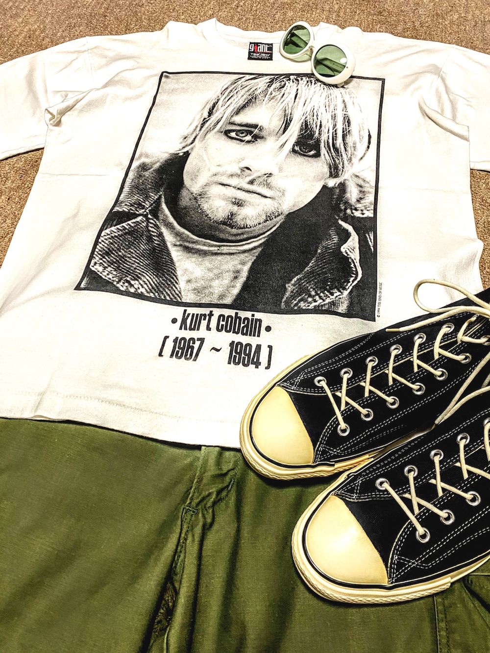 ホワイト系のTシャツ/カットソー、グリーン系のカーゴパンツ、ブラック系のスニーカーを着用したメンズの夏コーディネートの2枚目の写真