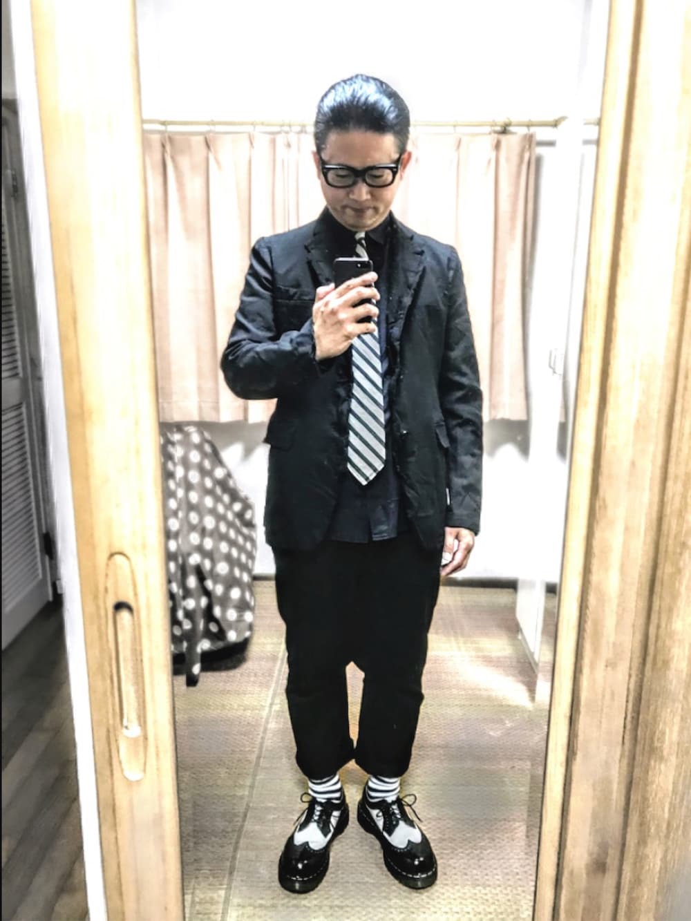 ブラック系のテーラードジャケット、ブラック系のシャツ/ブラウス、ホワイト系のネクタイを着用したメンズの秋コーディネートの2枚目の写真