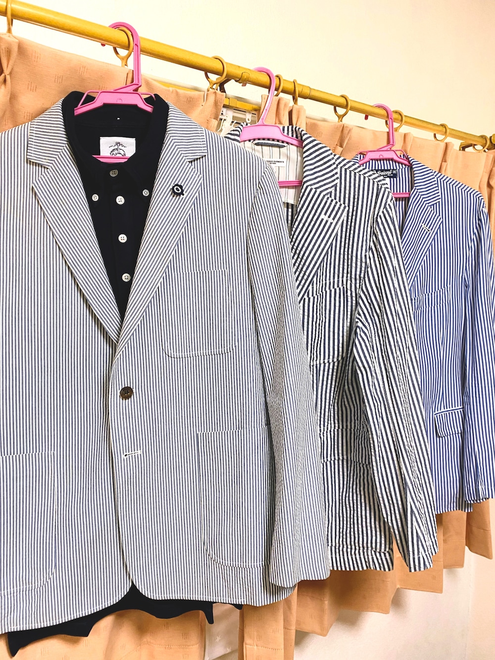 ブルー系のテーラードジャケット、ブルー系のポロシャツ、ホワイト系のデニムパンツを着用したメンズの夏コーディネートの2枚目の写真