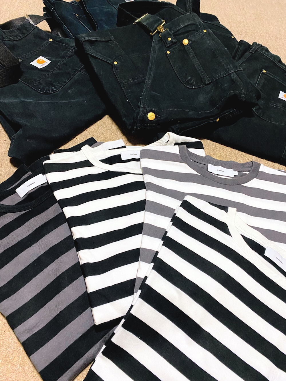 ホワイト系のTシャツ/カットソー、ブラック系のチノパンツ、ブラック系のスニーカーを着用したメンズの秋コーディネートの4枚目の写真