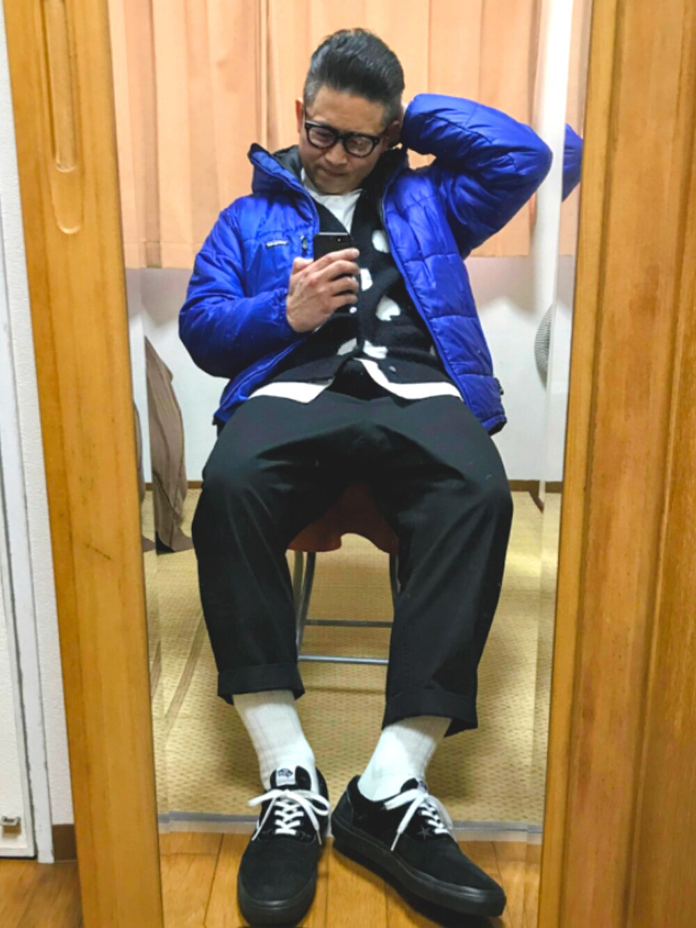 ブルー系のダウンジャケット/コート、ブラック系のカーディガン/ボレロ、ホワイト系のシャツ/ブラウスを着用したメンズの春コーディネートの2枚目の写真