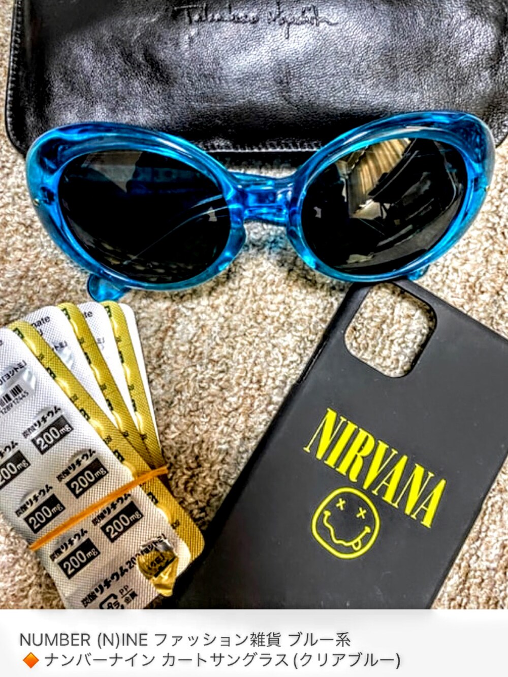 グリーン系のステンカラーコート、ブルー系のデニムパンツ、ブラック系のスニーカーを着用したメンズの秋コーディネートの4枚目の写真