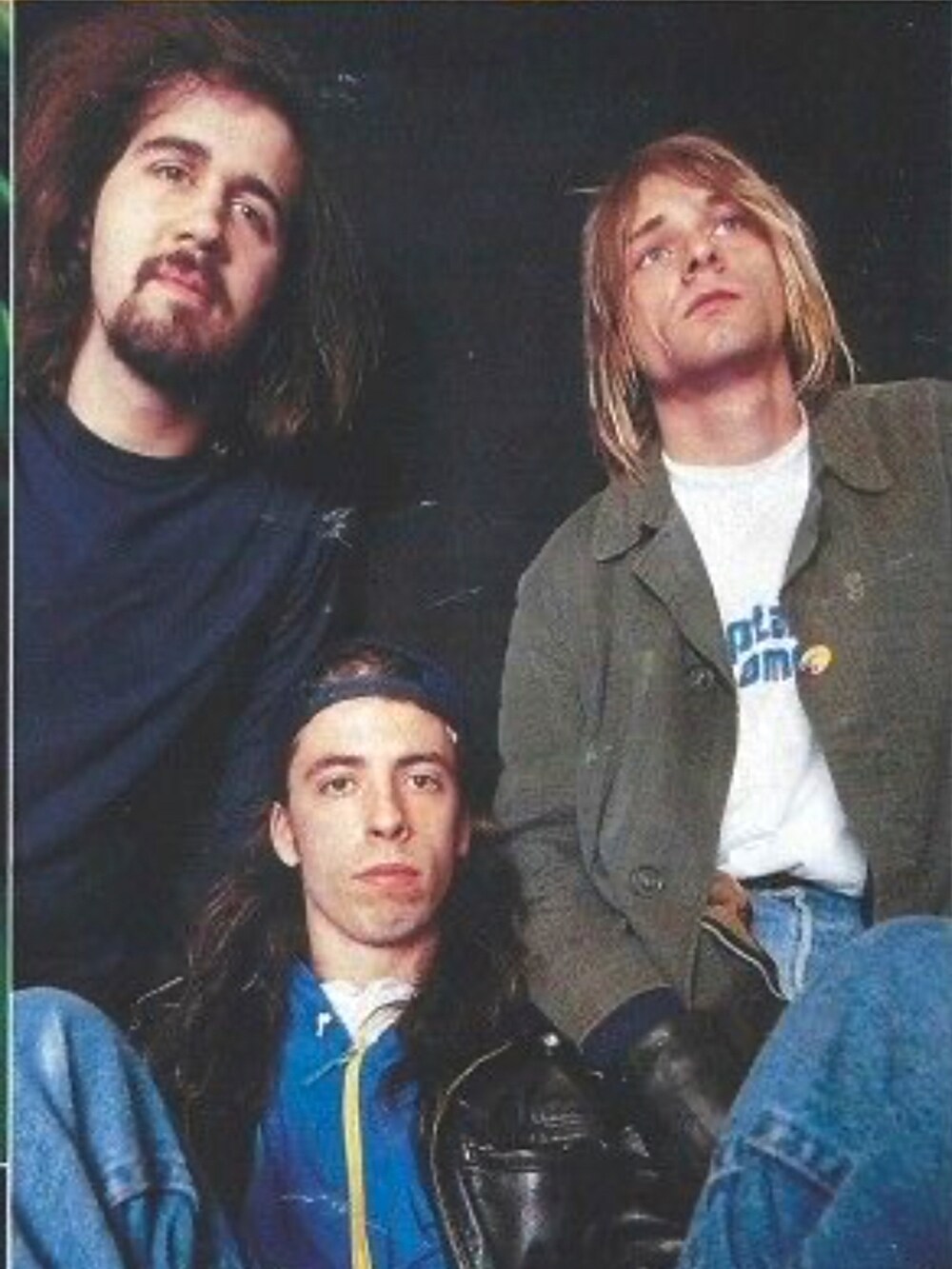 グリーン系のステンカラーコート、ブラック系のカーディガン/ボレロ、ホワイト系のTシャツ/カットソーを着用したメンズの冬コーディネートの3枚目の写真