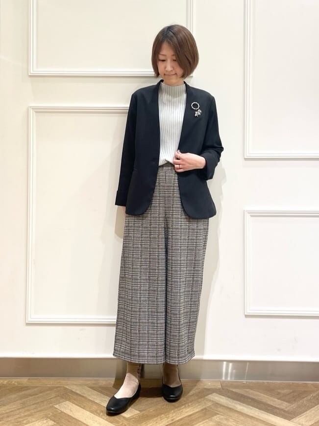 ブラック系のノーカラージャケット、グレー系のニット/セーター、ベージュ系のその他パンツを着用したレディースの冬コーディネートの6枚目の写真