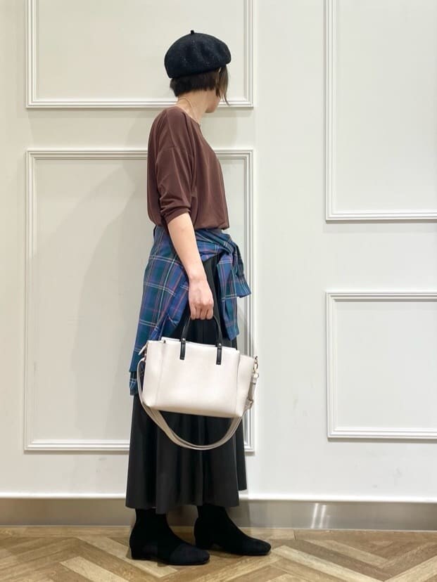 ブラウン系のTシャツ/カットソー、グリーン系のシャツ/ブラウス、ブラック系のスカートを着用したレディースの秋コーディネートの2枚目の写真
