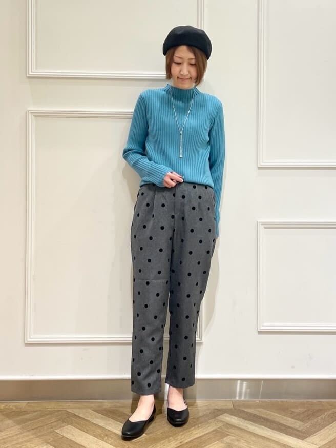 ブラック系のトレンチコート、ブルー系のニット/セーター、ブラック系のその他パンツを着用したレディースの春コーディネートの4枚目の写真