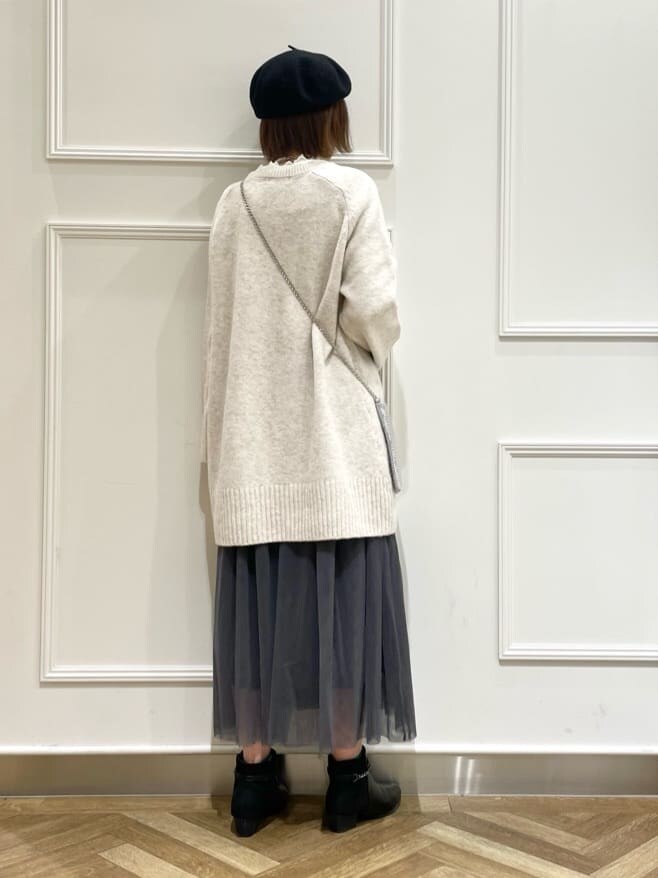ベージュ系のニット/セーター、ホワイト系のTシャツ/カットソー、グレー系のスカートを着用したレディースの冬コーディネートの3枚目の写真