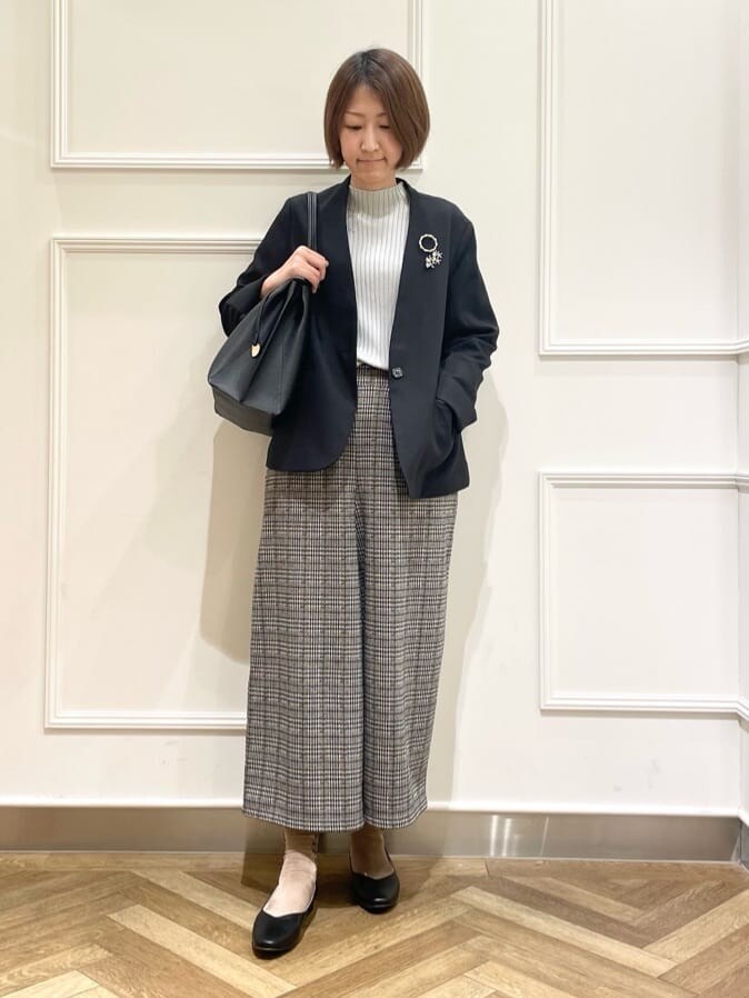 ブラック系のノーカラージャケット、グレー系のニット/セーター、ベージュ系のその他パンツを着用したレディースの冬コーディネートの2枚目の写真