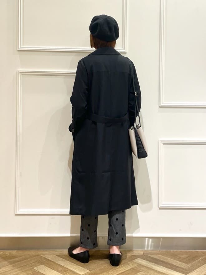 ブラック系のトレンチコート、ブルー系のニット/セーター、ブラック系のその他パンツを着用したレディースの春コーディネートの3枚目の写真
