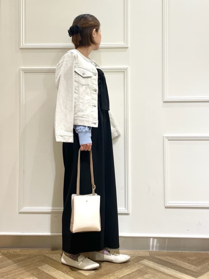 グレー系のデニムジャケット、ブラック系のサロペット/オーバーオール、ブルー系のニット/セーターを着用したレディースの春コーディネートの2枚目の写真