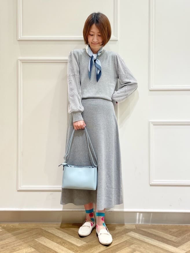 グレー系のニット/セーター、グレー系のスカート、ホワイト系のその他シューズを着用したレディースの春コーディネートの5枚目の写真