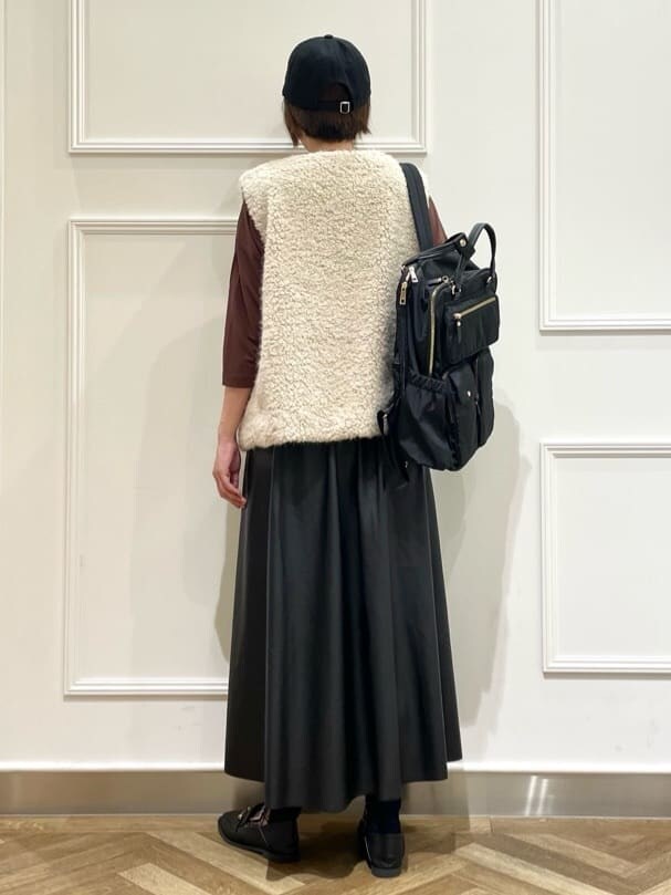 ベージュ系のベスト、ブラウン系のTシャツ/カットソー、ブラック系のスカートを着用したレディースの秋コーディネートの3枚目の写真