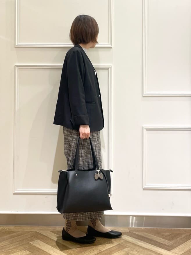 ブラック系のノーカラージャケット、グレー系のニット/セーター、ベージュ系のその他パンツを着用したレディースの冬コーディネートの3枚目の写真
