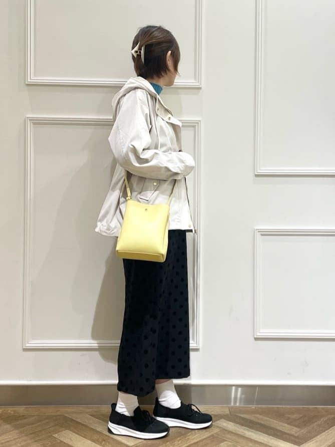 ホワイト系のブルゾン、ブルー系のニット/セーター、グレー系のスカートを着用したレディースの春コーディネートの2枚目の写真