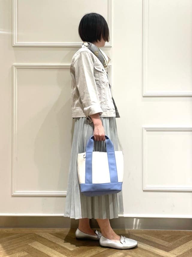 グレー系のデニムジャケット、ホワイト系のシャツ/ブラウス、グリーン系のスカートを着用したレディースの冬コーディネートの2枚目の写真