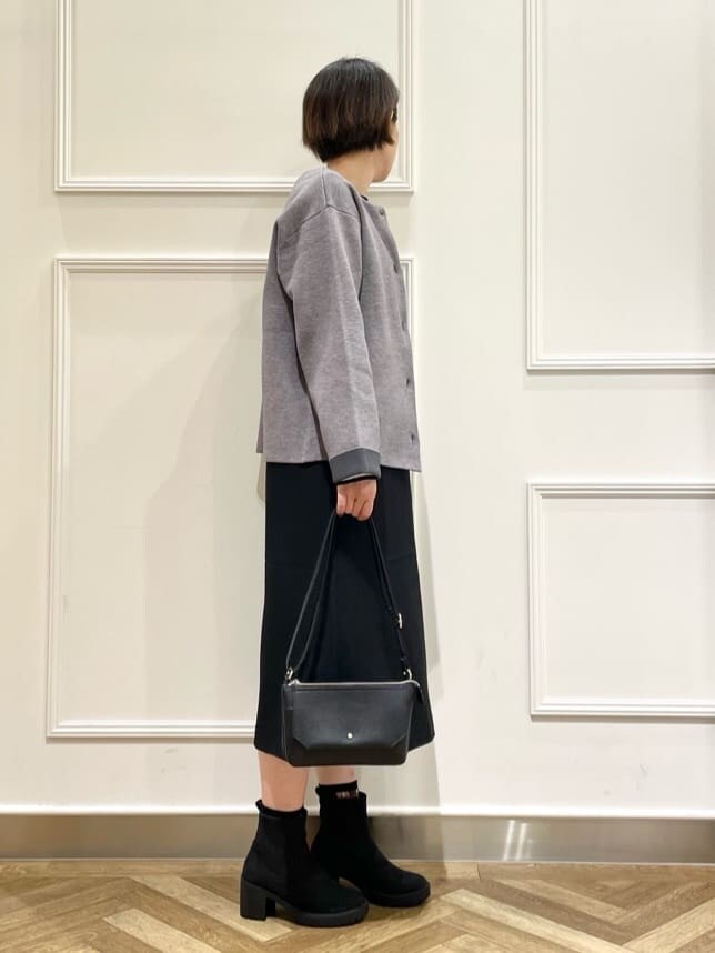 グレー系のカーディガン/ボレロ、ブラック系のワンピース、ホワイト系のニット/セーターを着用したレディースの冬コーディネートの2枚目の写真