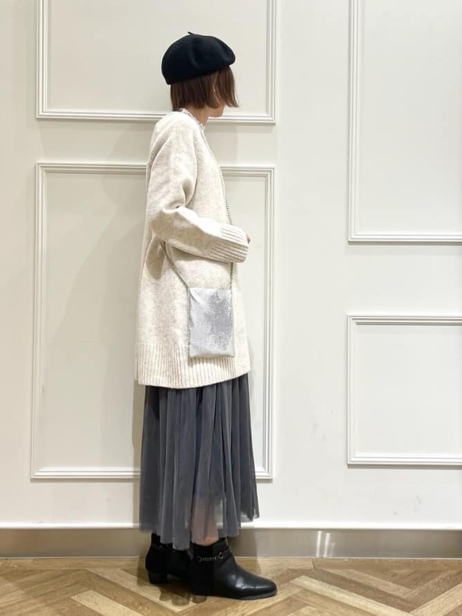 ベージュ系のニット/セーター、ホワイト系のTシャツ/カットソー、グレー系のスカートを着用したレディースの冬コーディネートの2枚目の写真