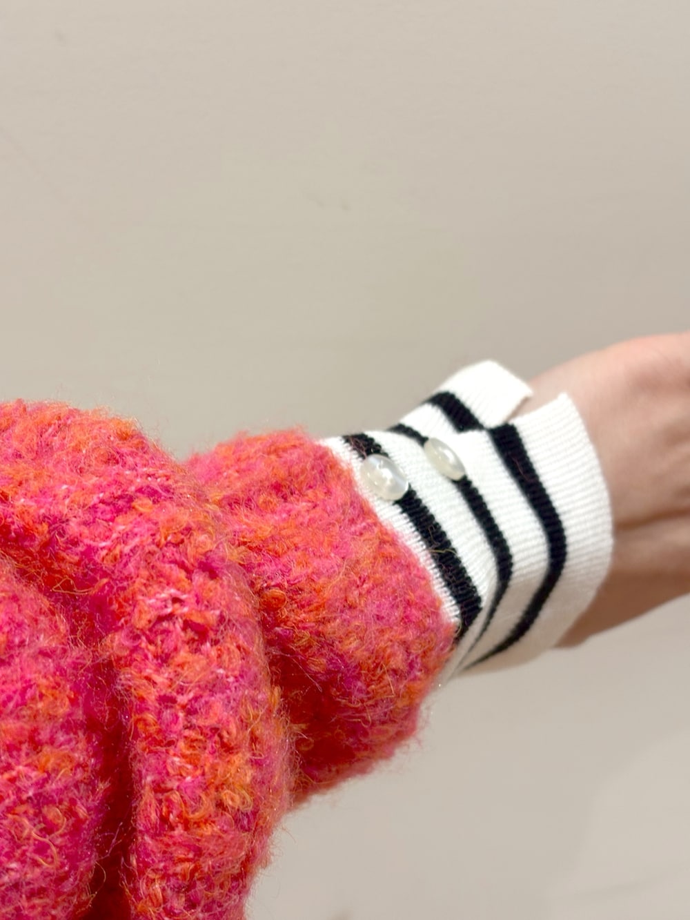 ホワイト系のニット/セーター、ピンク系のカーディガン/ボレロ、ブラウン系のスカートを着用したレディースの冬コーディネートの6枚目の写真