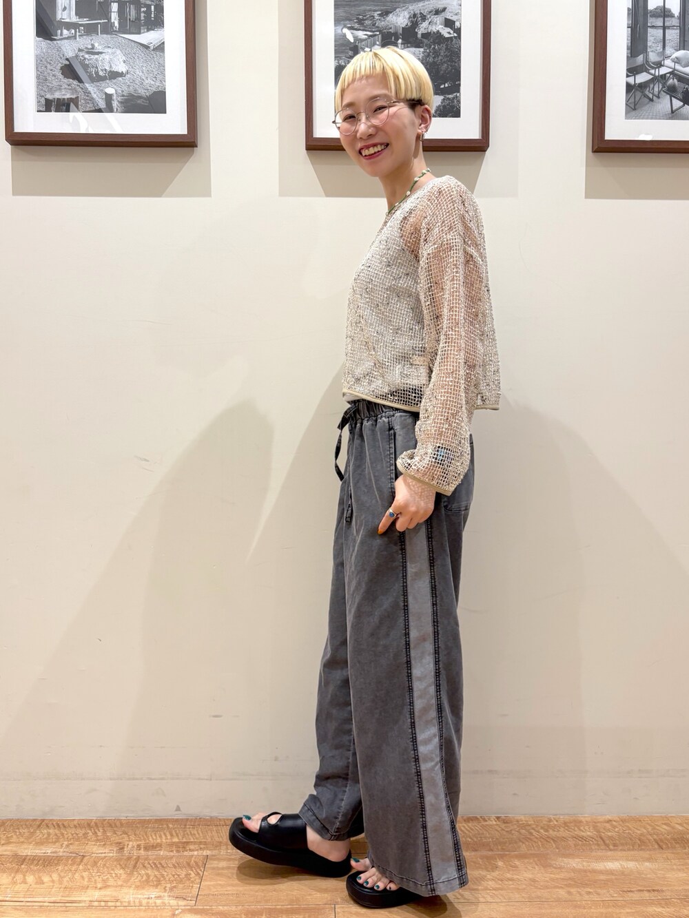 ブラック系のデニムパンツ、ホワイト系のカーディガン/ボレロ、シルバー系のタンクトップを着用したレディースの夏コーディネートの2枚目の写真