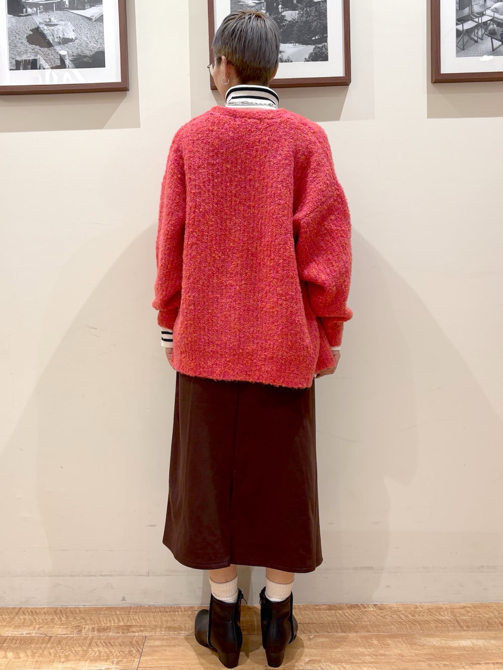 ホワイト系のニット/セーター、ピンク系のカーディガン/ボレロ、ブラウン系のスカートを着用したレディースの冬コーディネートの4枚目の写真