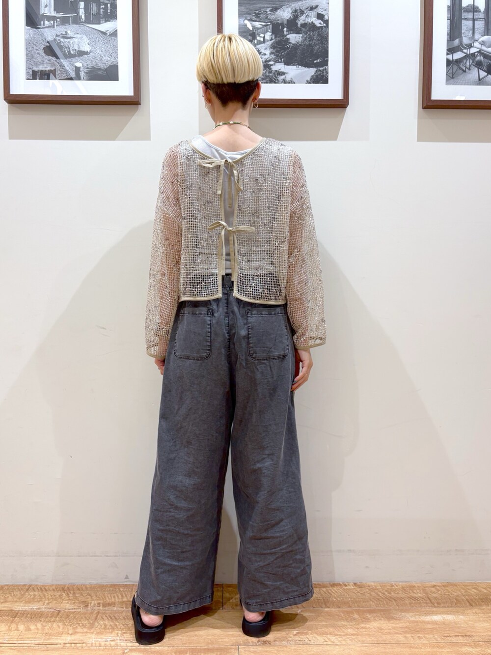 ブラック系のデニムパンツ、ホワイト系のカーディガン/ボレロ、シルバー系のタンクトップを着用したレディースの夏コーディネートの4枚目の写真