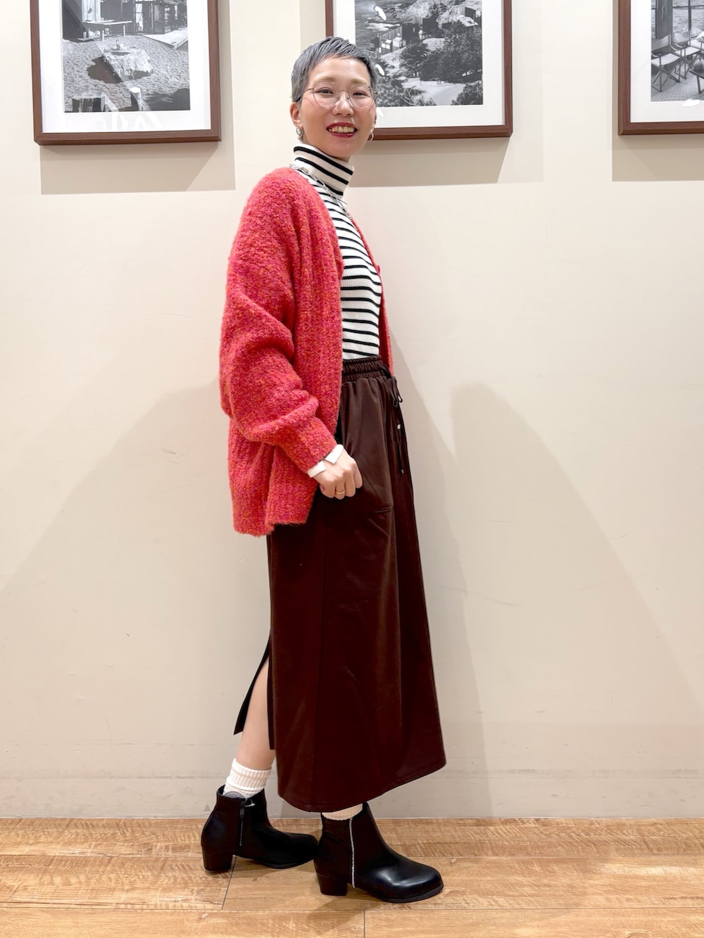 ホワイト系のニット/セーター、ピンク系のカーディガン/ボレロ、ブラウン系のスカートを着用したレディースの冬コーディネートの2枚目の写真