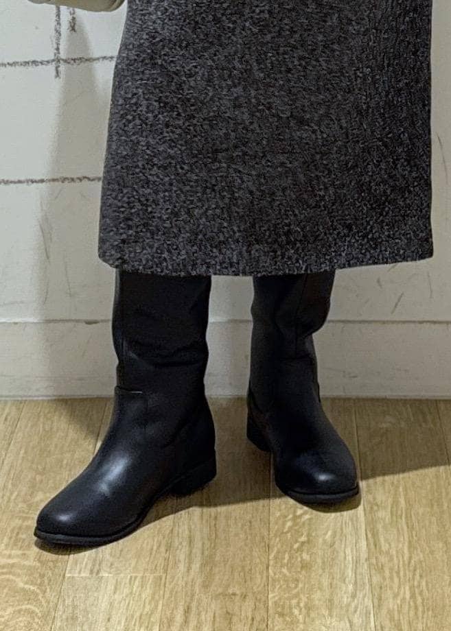 ブルー系のニット/セーター、ブラック系のブーツ、シルバー系のショルダーバッグを着用したレディースの冬コーディネートの7枚目の写真