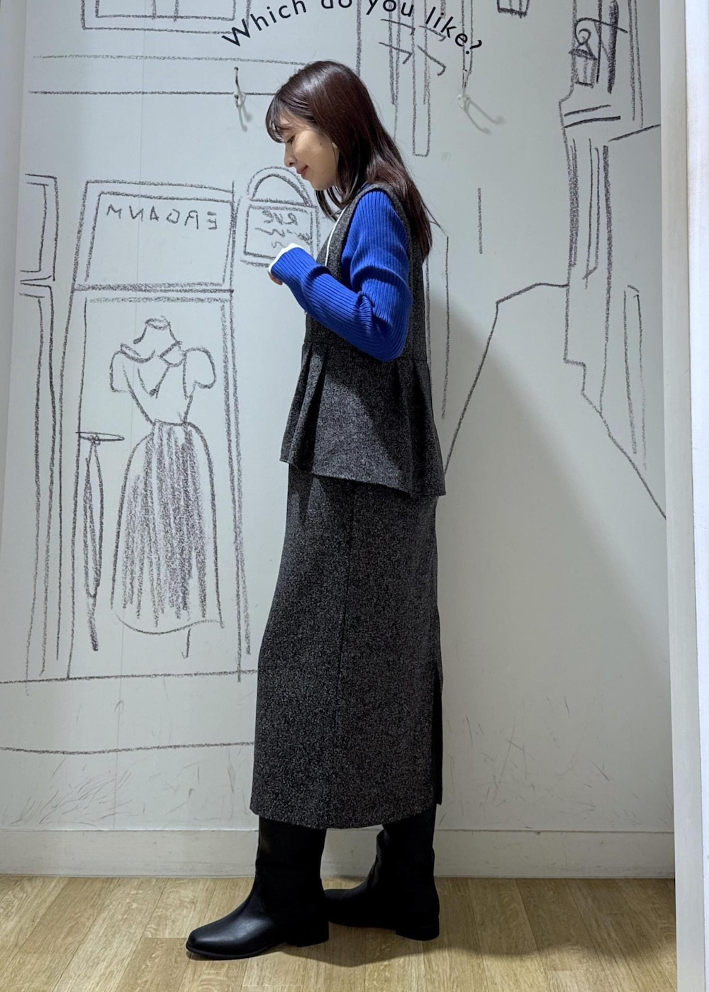 ブルー系のニット/セーター、ブラック系のブーツ、シルバー系のショルダーバッグを着用したレディースの冬コーディネートの4枚目の写真