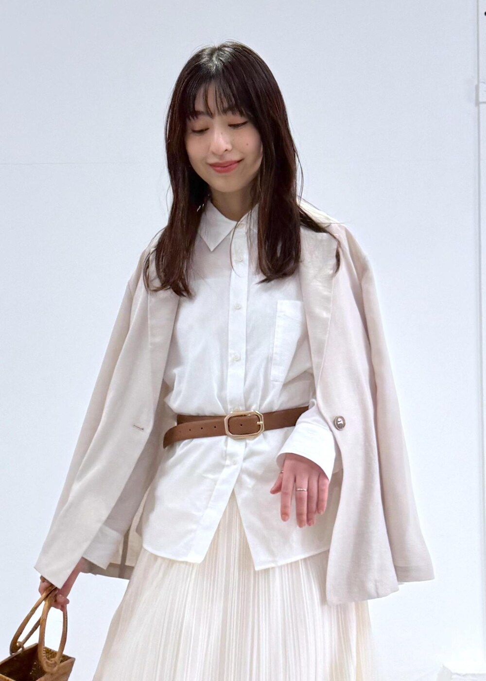 ホワイト系のパンプス、ホワイト系のスカート、ホワイト系のシャツ/ブラウスを着用したレディースの冬コーディネートの2枚目の写真