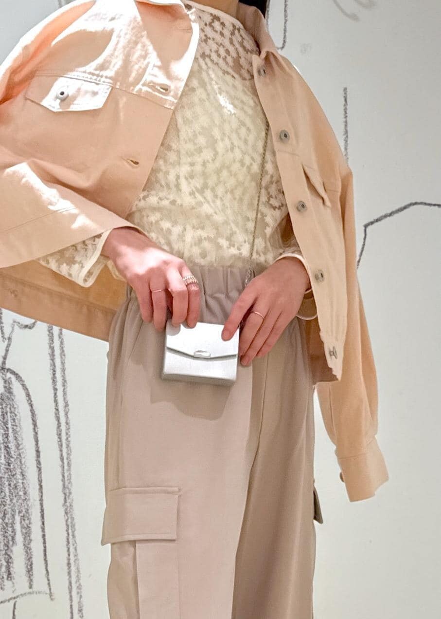 シルバー系のパンプス、ホワイト系のシャツ/ブラウス、シルバー系のショルダーバッグを着用したレディースの春コーディネートの6枚目の写真