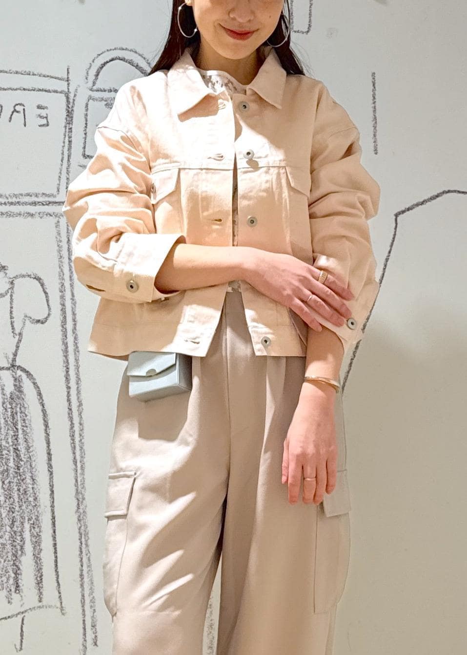 シルバー系のパンプス、ホワイト系のシャツ/ブラウス、シルバー系のショルダーバッグを着用したレディースの春コーディネートの2枚目の写真
