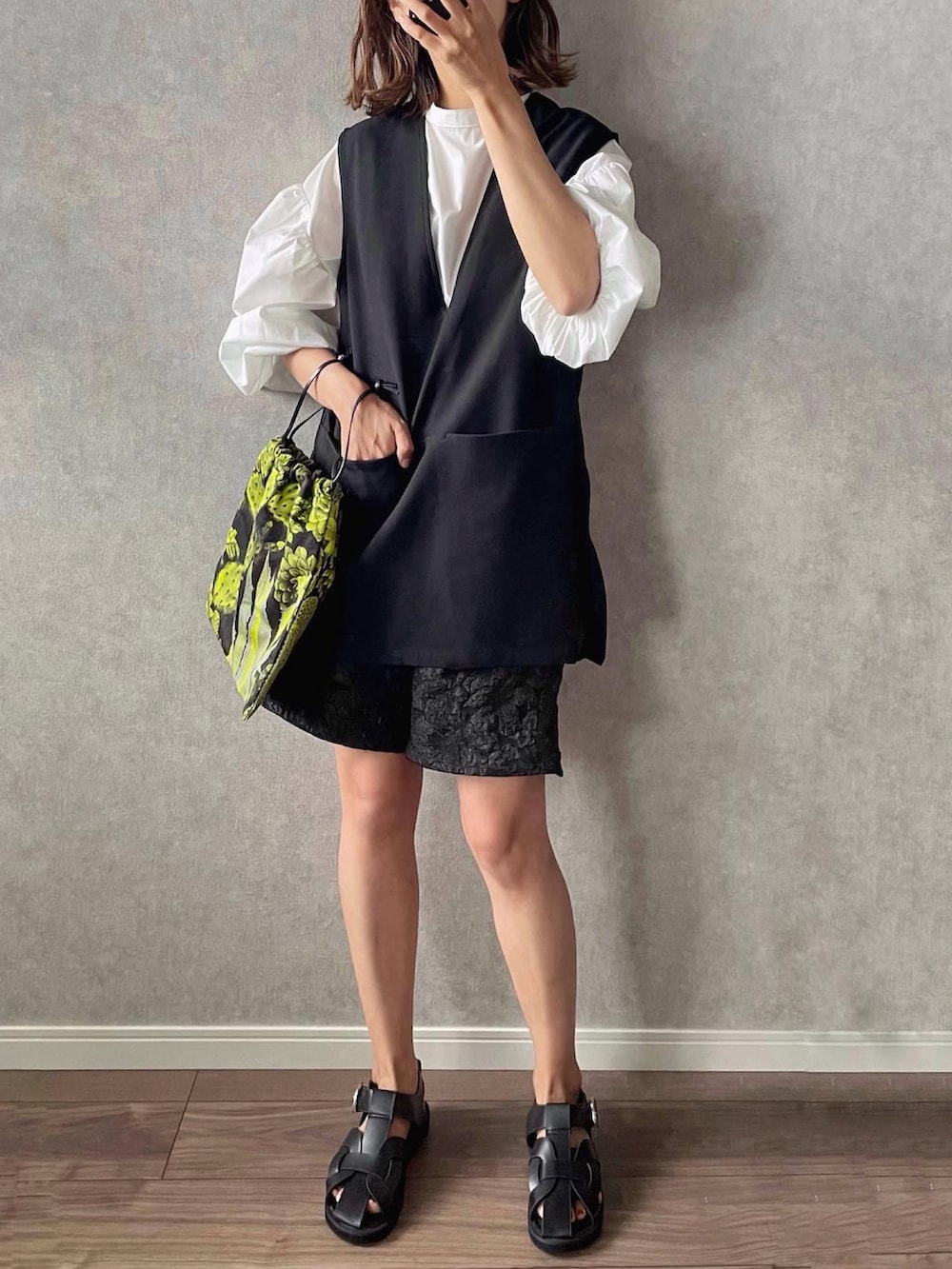 ブラック系のサンダル、ブラック系のその他パンツ、ブラック系のベストを着用したレディースの夏コーディネートの2枚目の写真