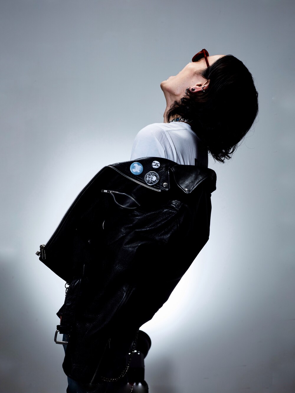 ブラック系のライダースジャケット、ホワイト系のTシャツ/カットソー、ブルー系のデニムパンツを着用したメンズの夏コーディネートの3枚目の写真