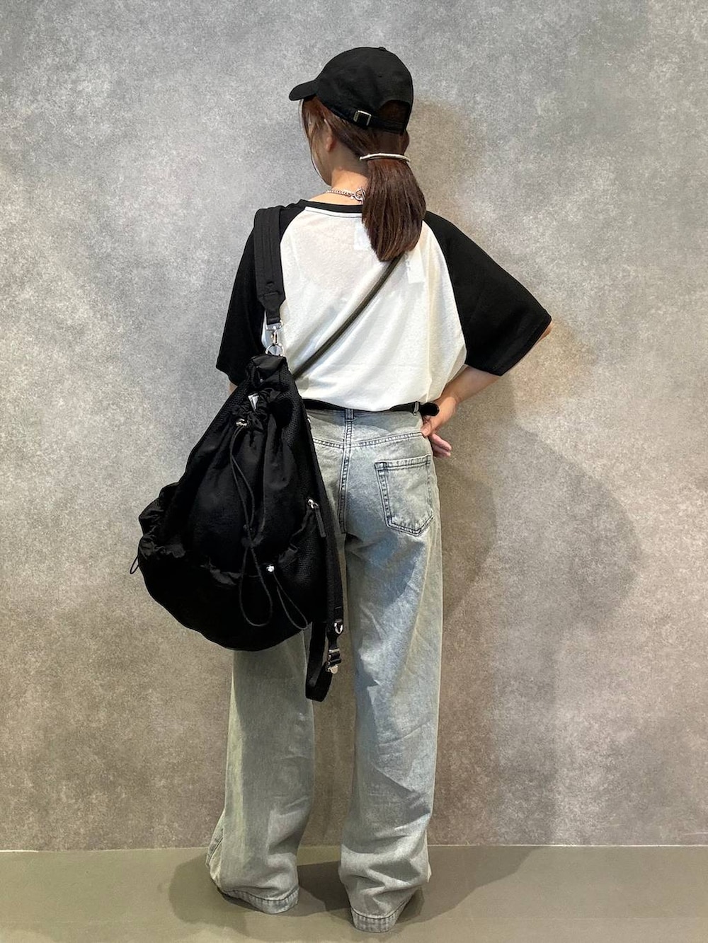 ブラック系のサンダル、ブルー系のデニムパンツ、ブラック系のバックパック/リュックを着用したレディースの夏コーディネートの3枚目の写真