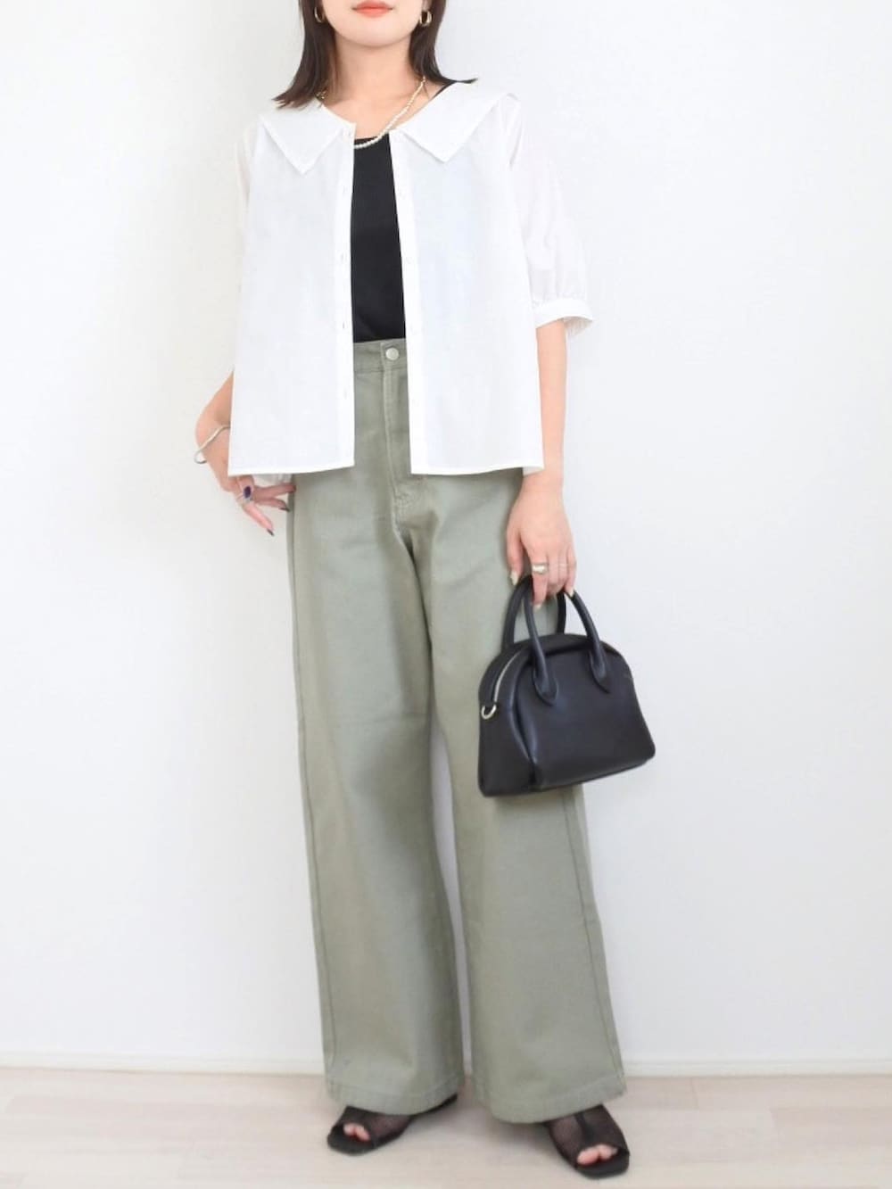 ブラック系のTシャツ/カットソー、グリーン系のデニムパンツを着用したレディースの夏コーディネートの2枚目の写真