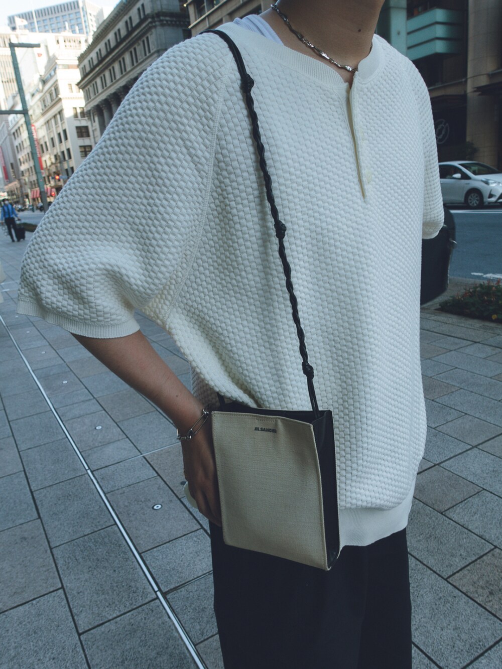 グレー系のスニーカー、ホワイト系のショルダーバッグを着用したメンズの夏コーディネートの2枚目の写真