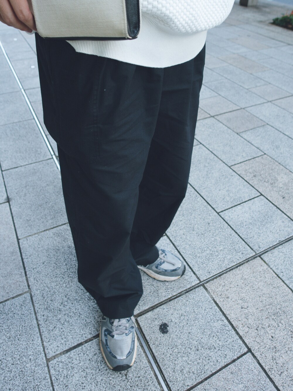 グレー系のスニーカー、ホワイト系のショルダーバッグを着用したメンズの夏コーディネートの3枚目の写真